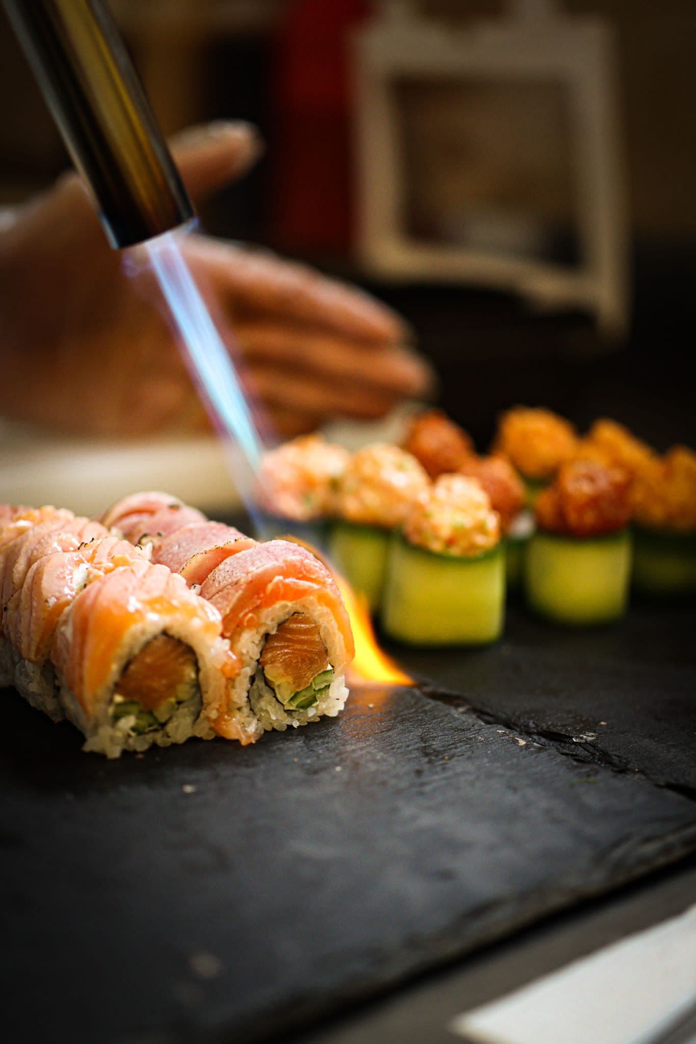 Chef finishing sashimi with herbs